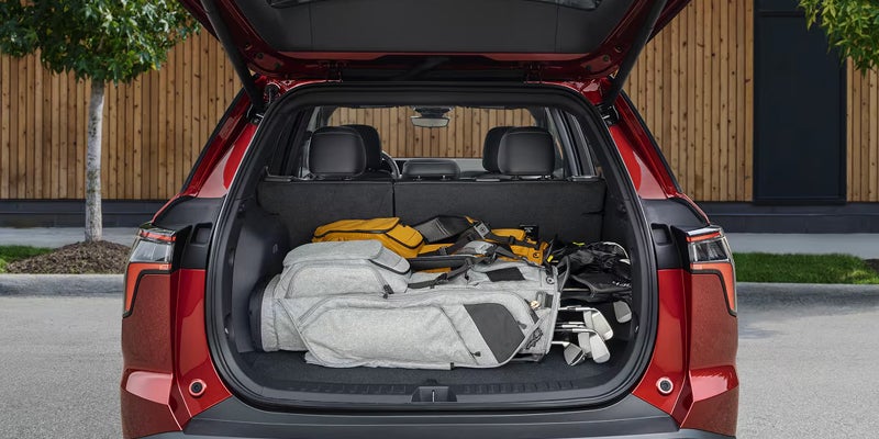 Open rear cargo area of a 2027 Chevrolet Equinox loaded with bags and gear.
